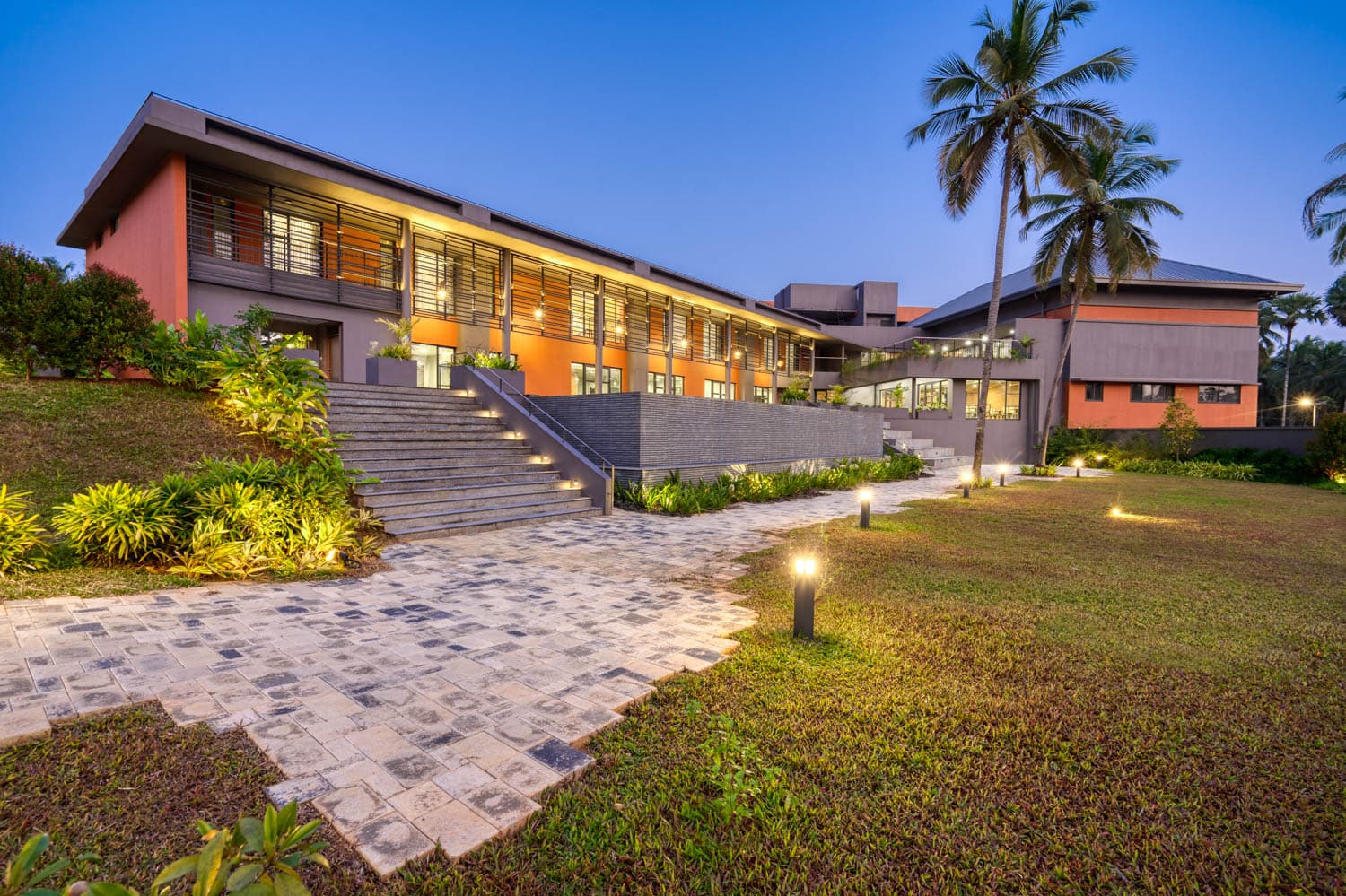 Landscaped walkway and building facade at dusk, Ananta Living Dharani, Palakkad, Kerala