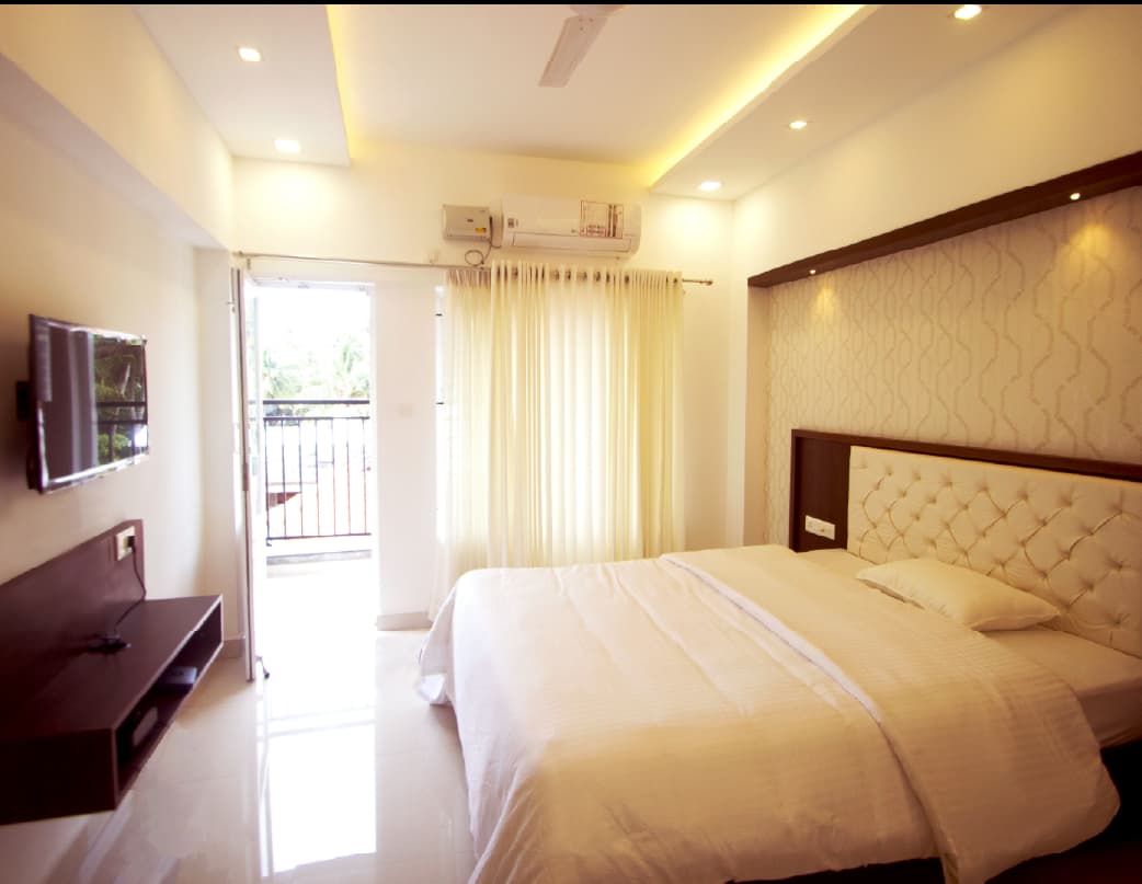 Studio apartment bedroom with wall-mounted TV at Season Two — Pettah, Thiruvananthapuram, Kerala